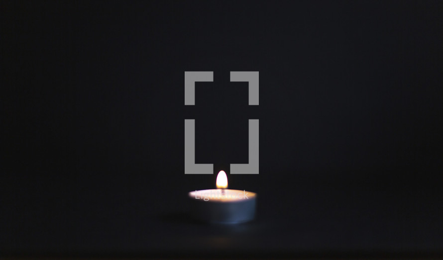 one single candle in dark room