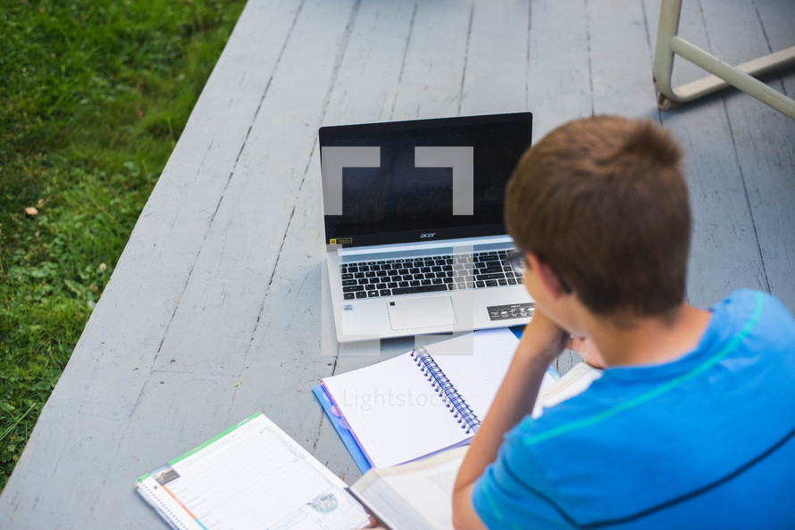 a child working on school work outdoors 