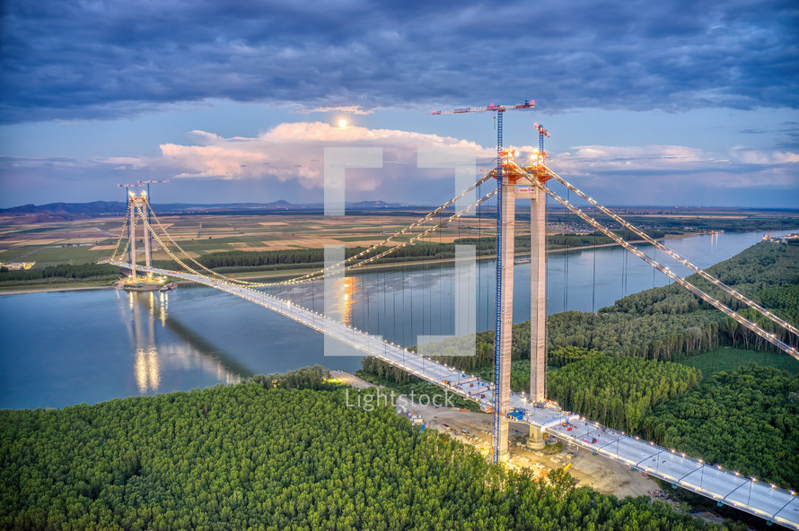 Panoramic aerial drone view from above of the suspended bridge over danube river, under construction