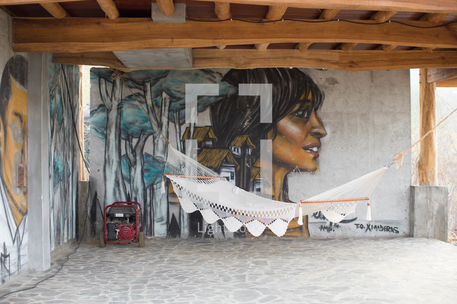 hammock and generator in front of a mural on a wall 