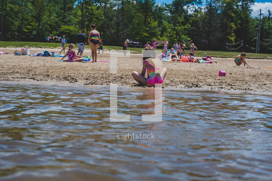 people on a lake beach in summer 