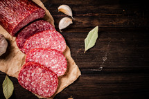 Delicious salami sausage on the table. On a black background. High quality photo