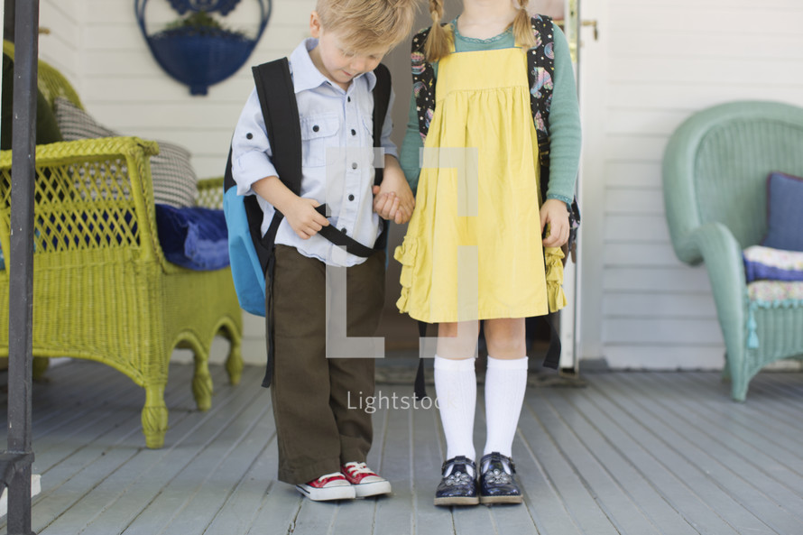 brother and sister holding hands on the first day of school 