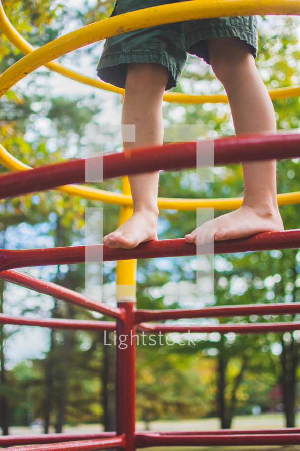 feet of a toddler boy on playground equipment 