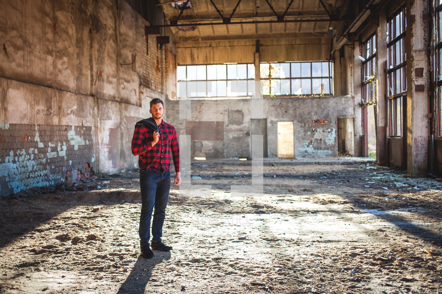 a man standing in an old empty warehouse building 
