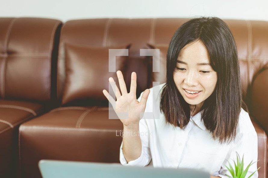 woman raising her hand while on a video conference call 