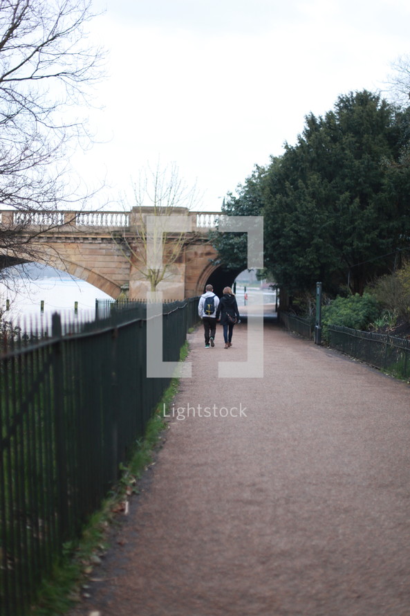 couple walking under a bridge 
