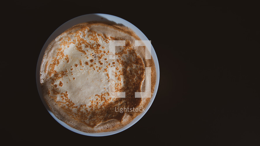 Top view of thin pancake on black background and copy space