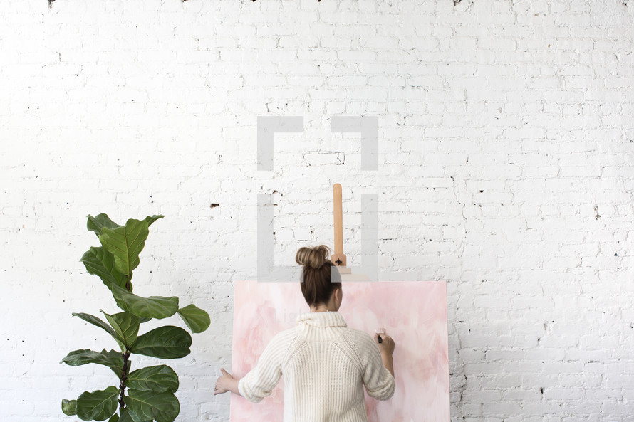 A woman painting on a canvas 