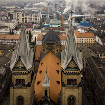 aerial view over a cathedral and smokestacks 