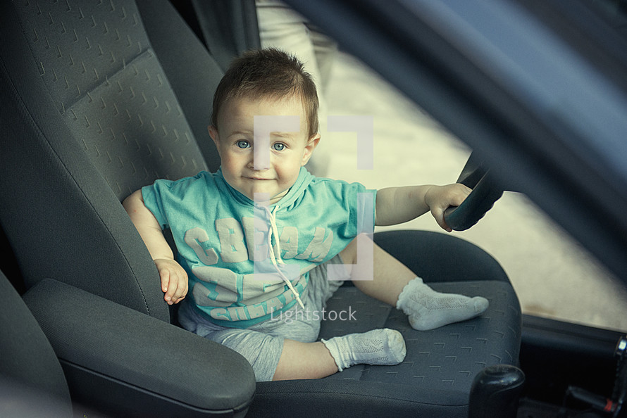toddler boy pretending to drive 