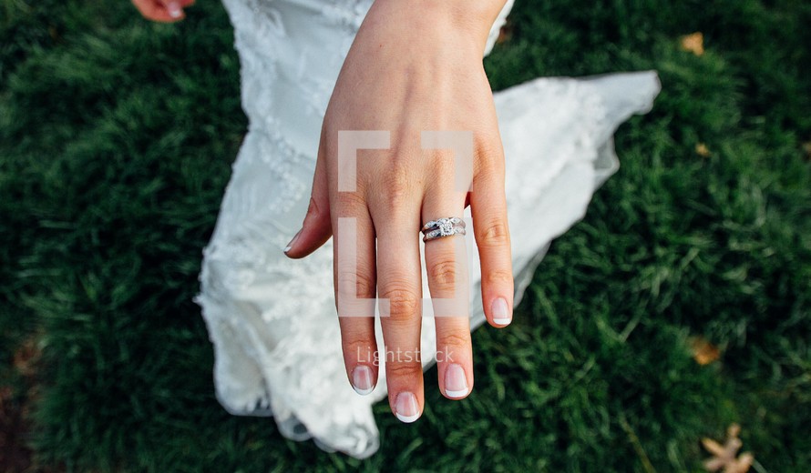 an engagement ring and wedding band on a bride 