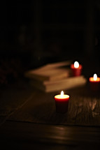 candles burning and a stack of books