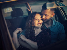 couple sitting in a car snuggling 