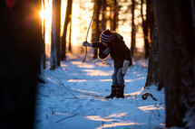 a child playing in snow in a forest 