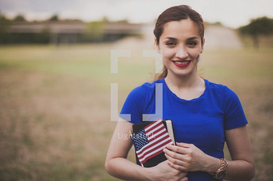 Woman holding a Bible, American flag, and a temporary tattoo 