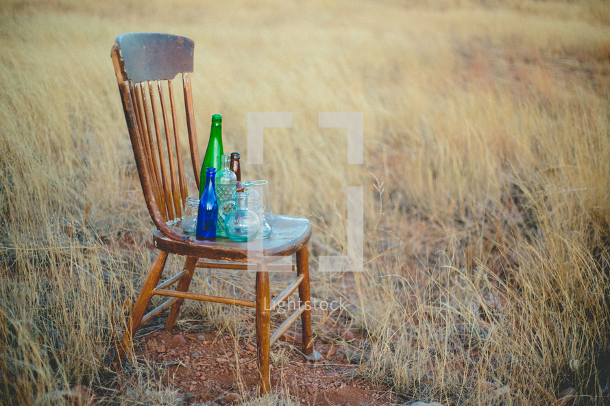 glass bottle on a wood chair outdoors 