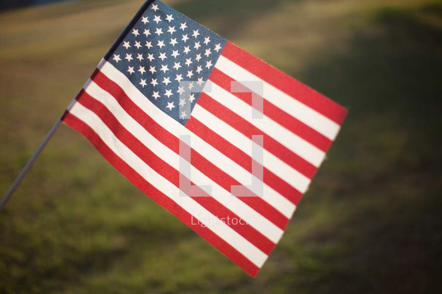 An American Flag being held up in a field