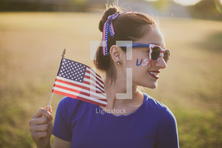 woman holding an American flag for July 4th 