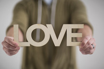 a man holding a sign of the word love 