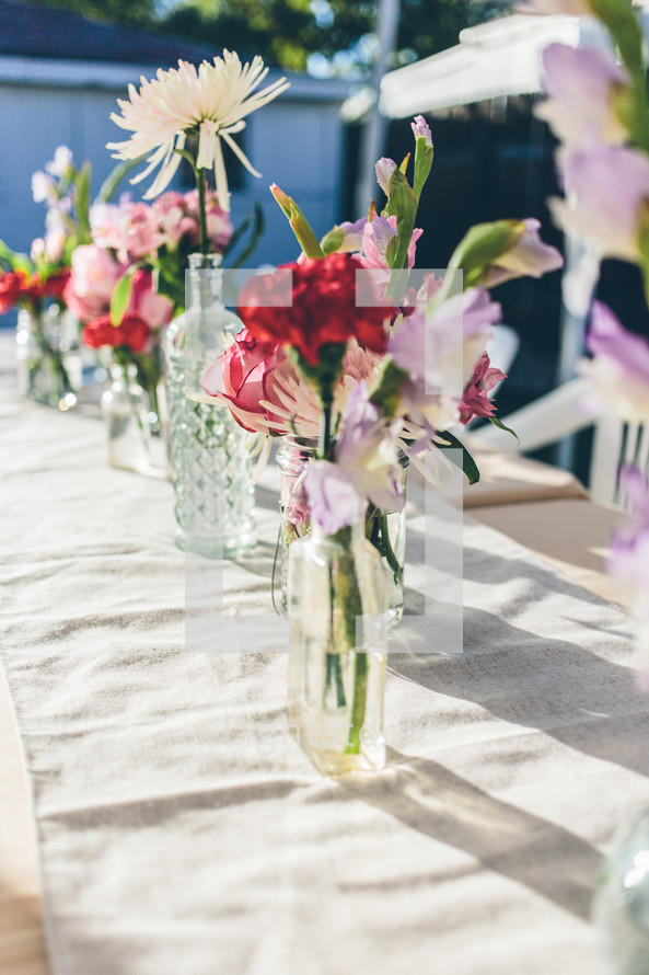 flowers in glass bottles on a table 