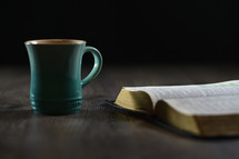 Bible on a table and a mug