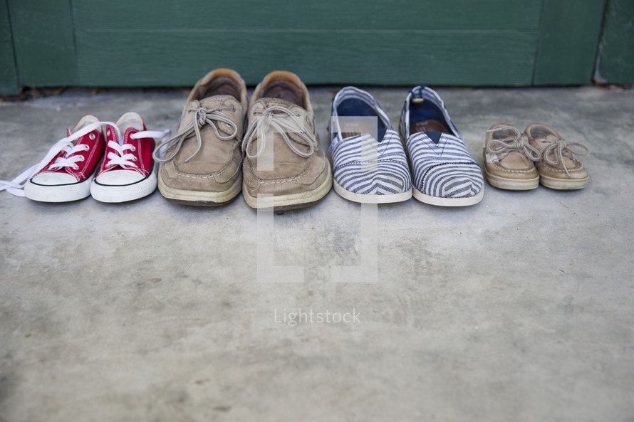 row of a families shoes in front of a door at home