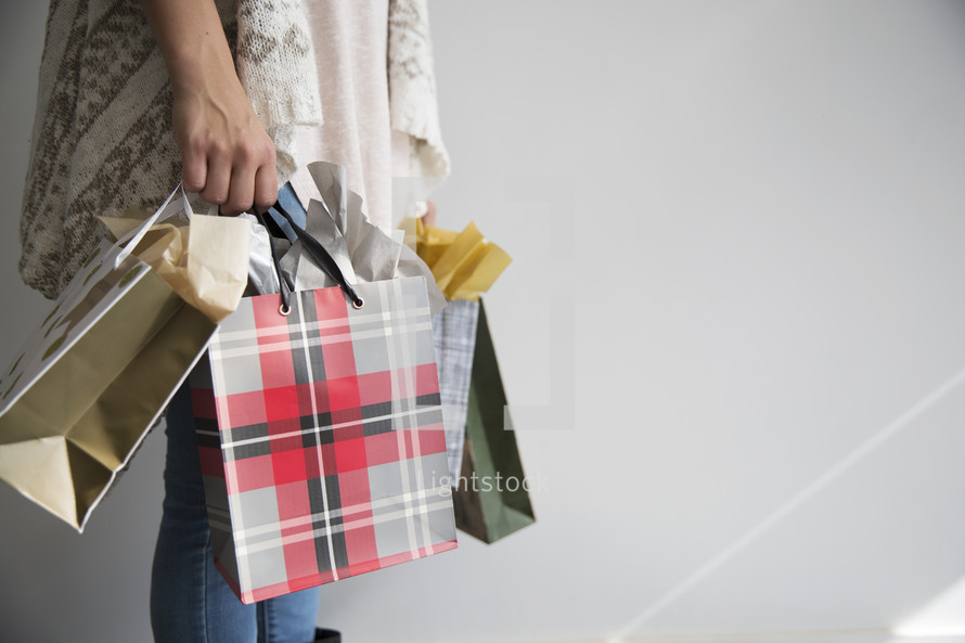 a woman holding Christmas gift bags 