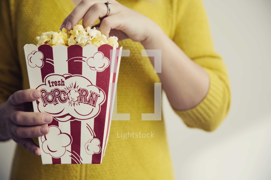 woman holding a box of popcorn 