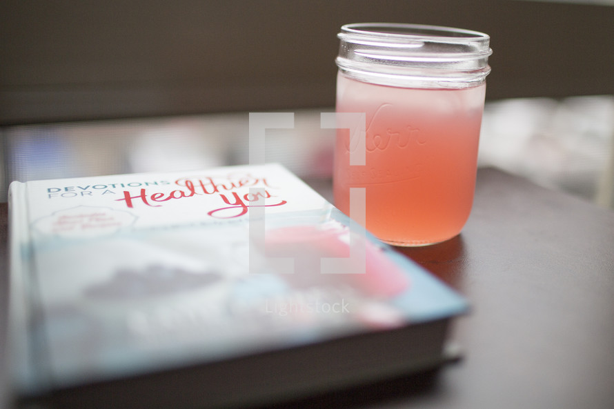 An iced beverage next to a book about health.