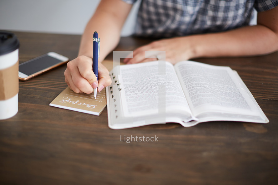 a woman reading a Bible and taking notes 