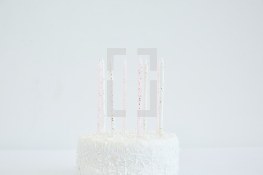 white birthday cake and birthday candles 