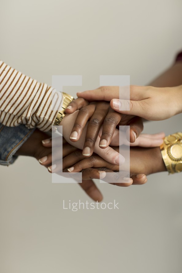 stacked hands in group prayer 