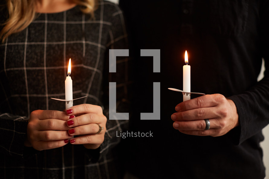 a man and woman holding a candle 