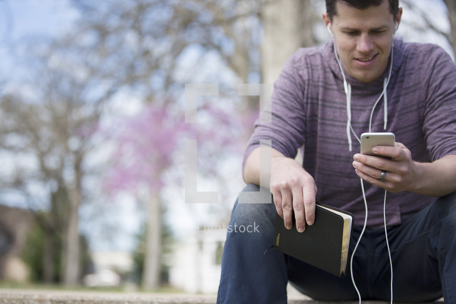 a man listening to a podcast outdoors