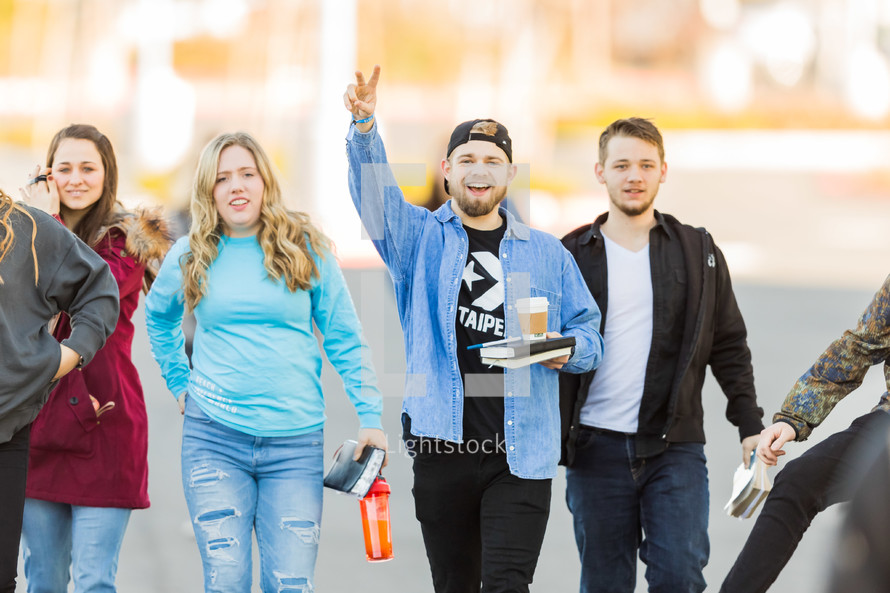 young adults walking in a group with Bibles 