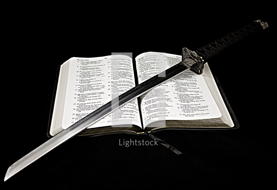 sword lying on the pages of a Bible 