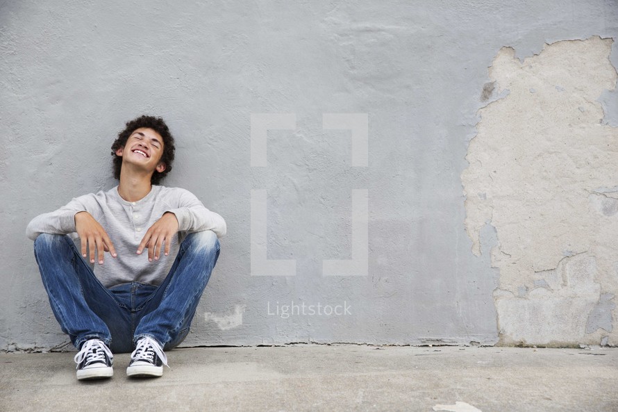 a teen boy sitting and waiting 