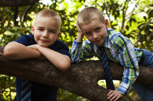 boys all dressed up hanging out in a tree