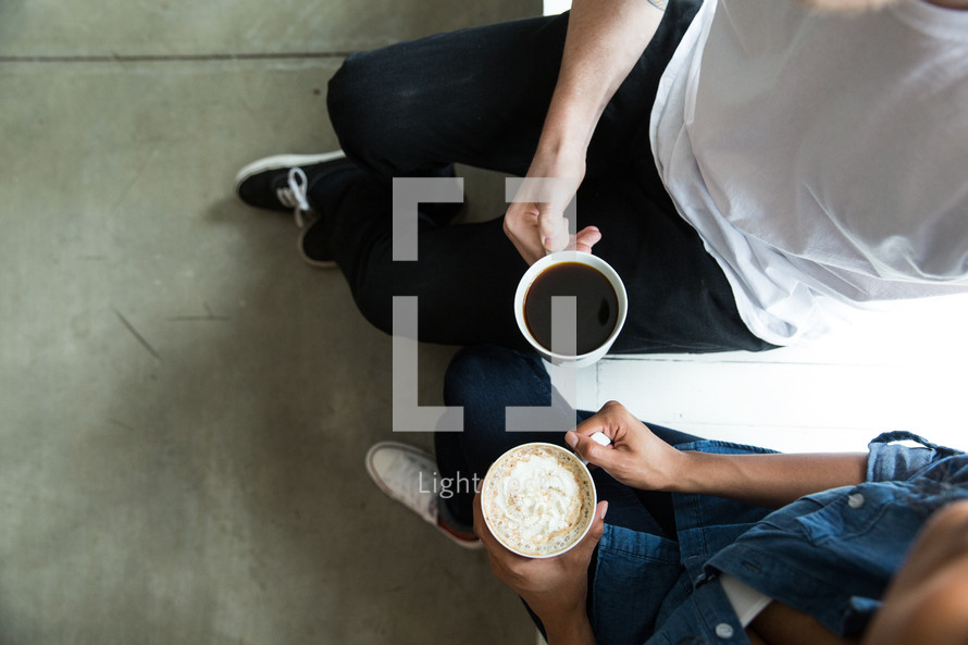 A man and woman sitting and having coffee together.