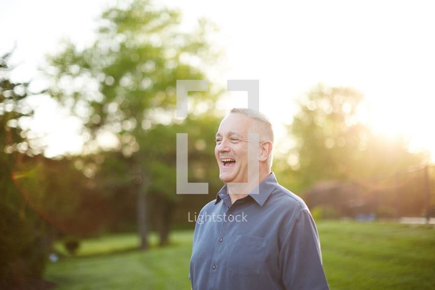 a man laughing outdoors 