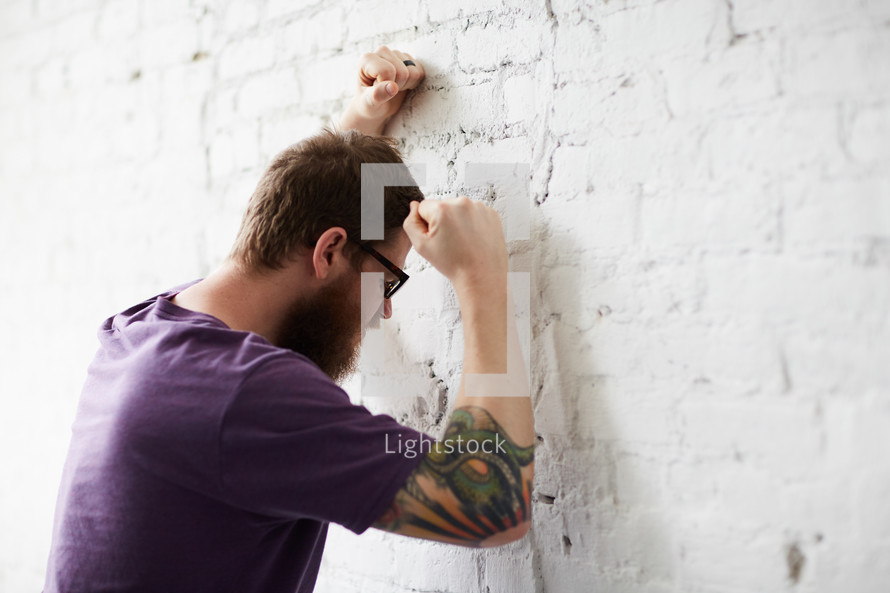 a man beating his fists against a wall 