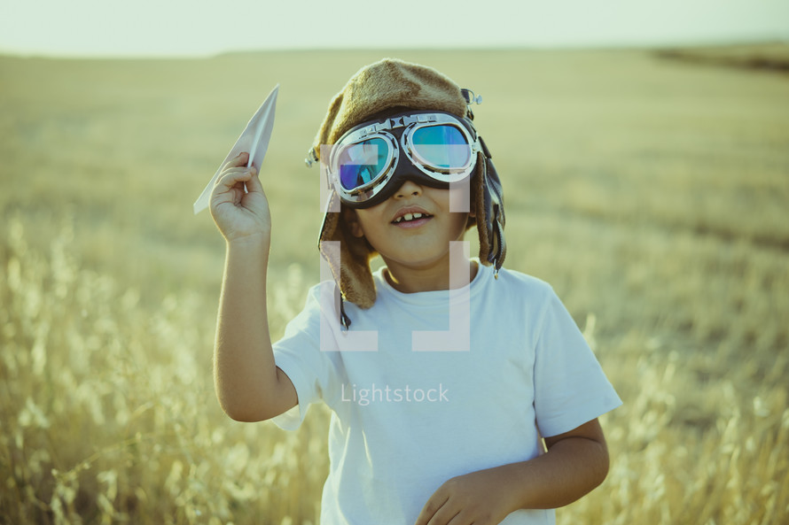 a kid playing with a paper airplane 
