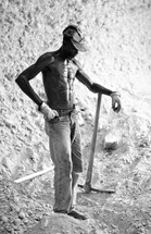 Sweating man holding a trench digger