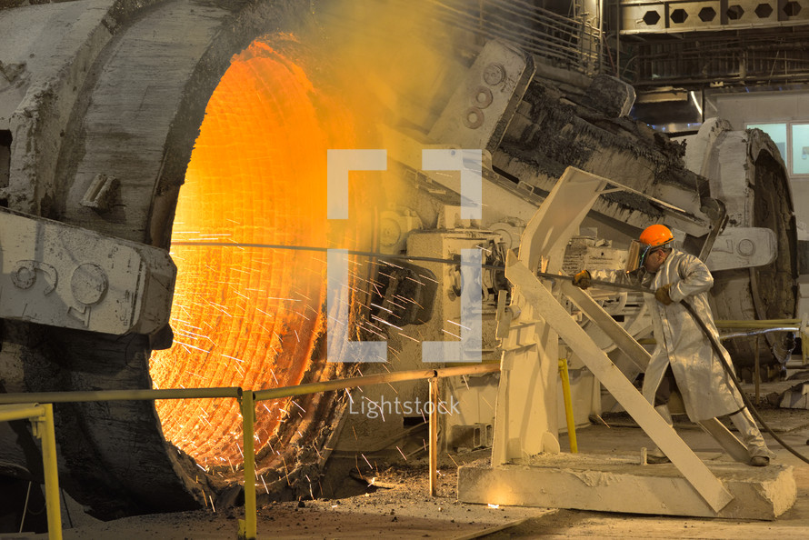 Industrial worker in steel making factory, near intense heat