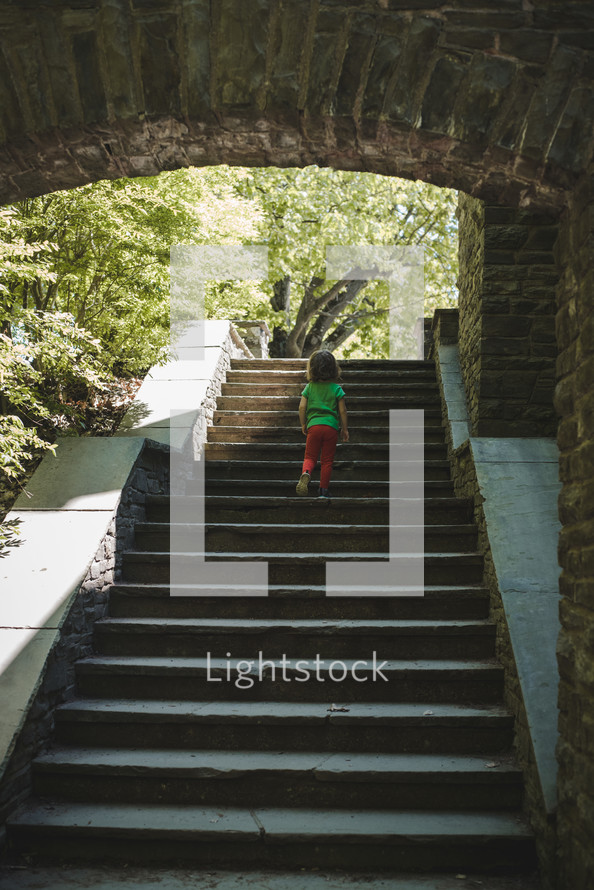 toddler girl exploring stone steps 
