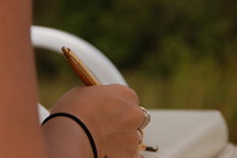 A woman's hand holding an ink pen.