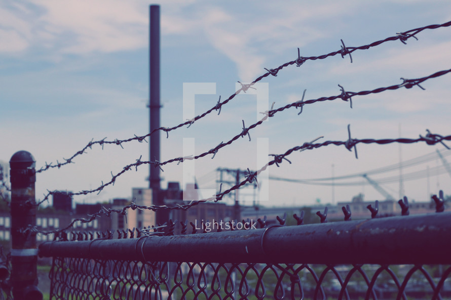 barbed wire at the top of a fence at a prison 