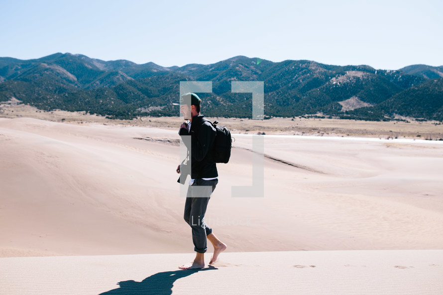 man walking barefoot in the desert 