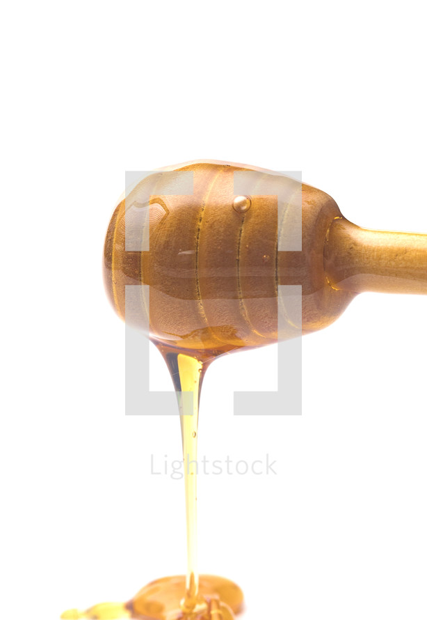 Honey with a Honeycomb Spoon on a White Background